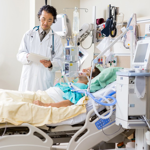 Doctor With Digital Tablet Examining Patient's Report In Hospital